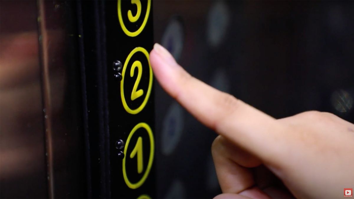 A finger pointing on an elevator button