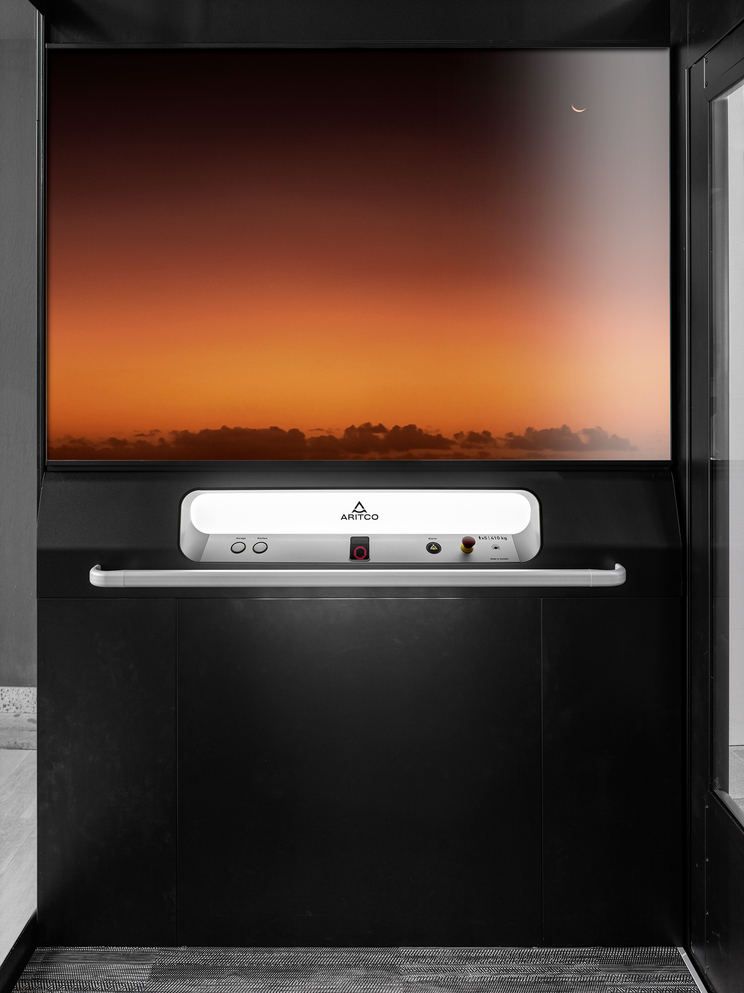 Home elevator Aritco Homelift Access with a designwall of a beautiful Florida sunset