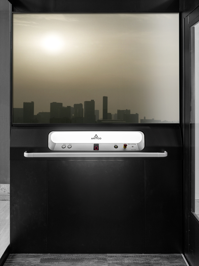The home lift Aritco Homelift access with a designwall with a skyline