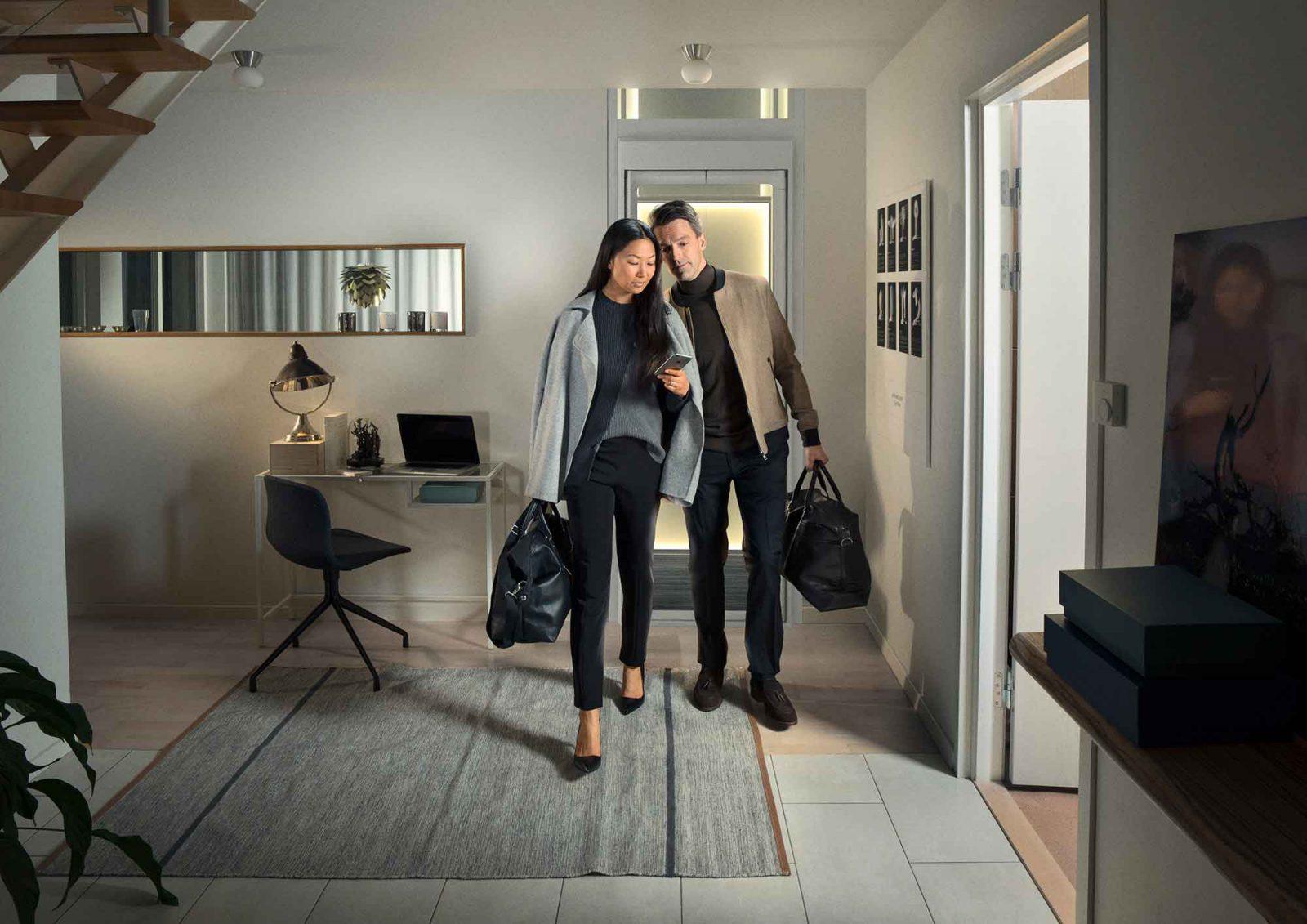 A couple in front of a home lift, elevator. Model Aritco HomeLift