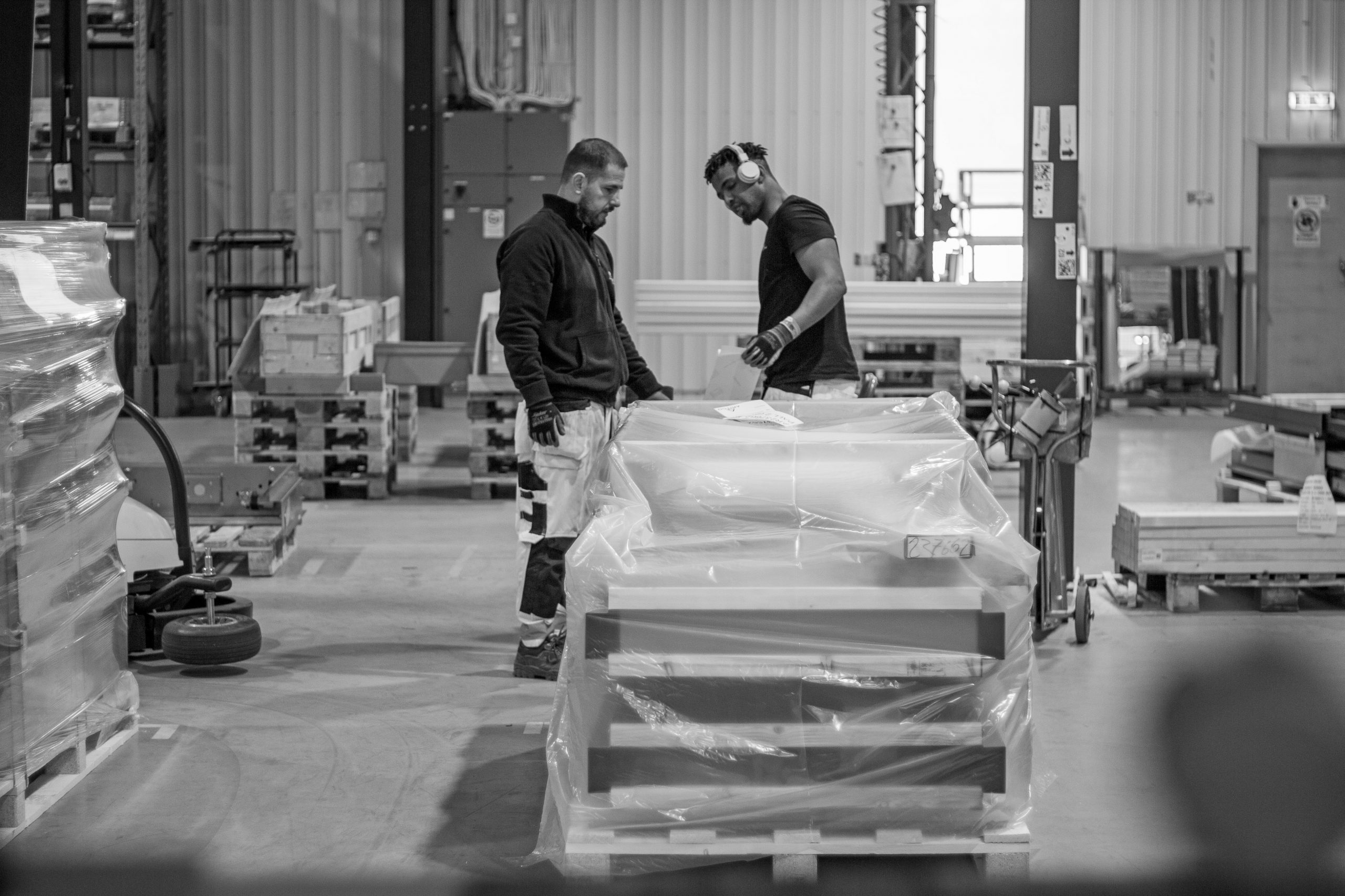Black and white photo of two men working in a production area