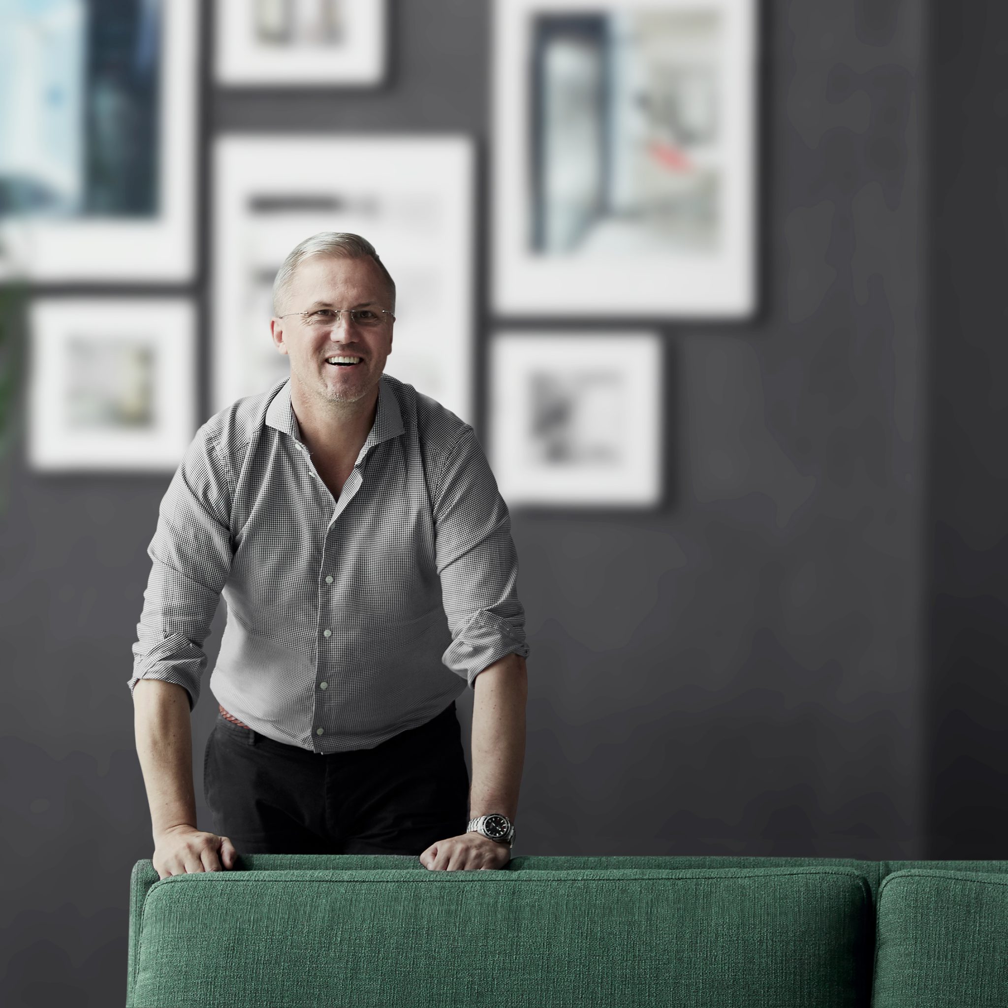 Martin Idbrant CEO at Aritco is smiling to the camera behind a green sofa