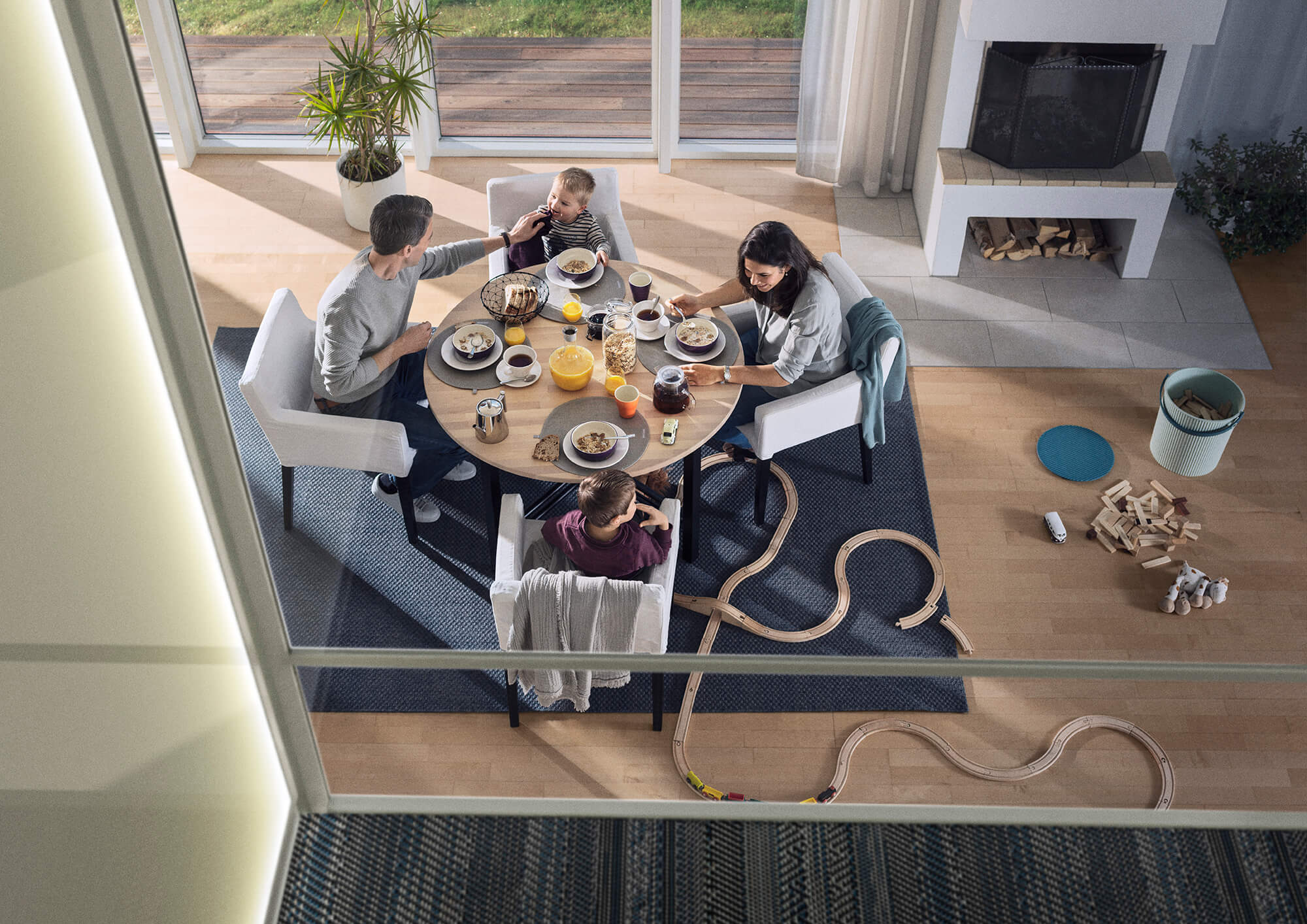 Inside an Aritco home elevator looking down on a family eating breakfast through its glass walls