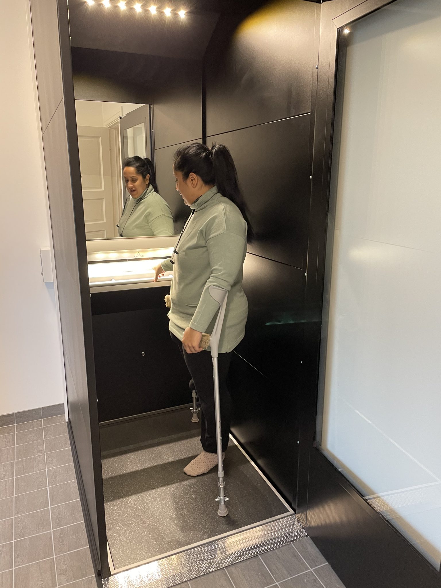 A woman in dark hair standing in an Aritco home lift