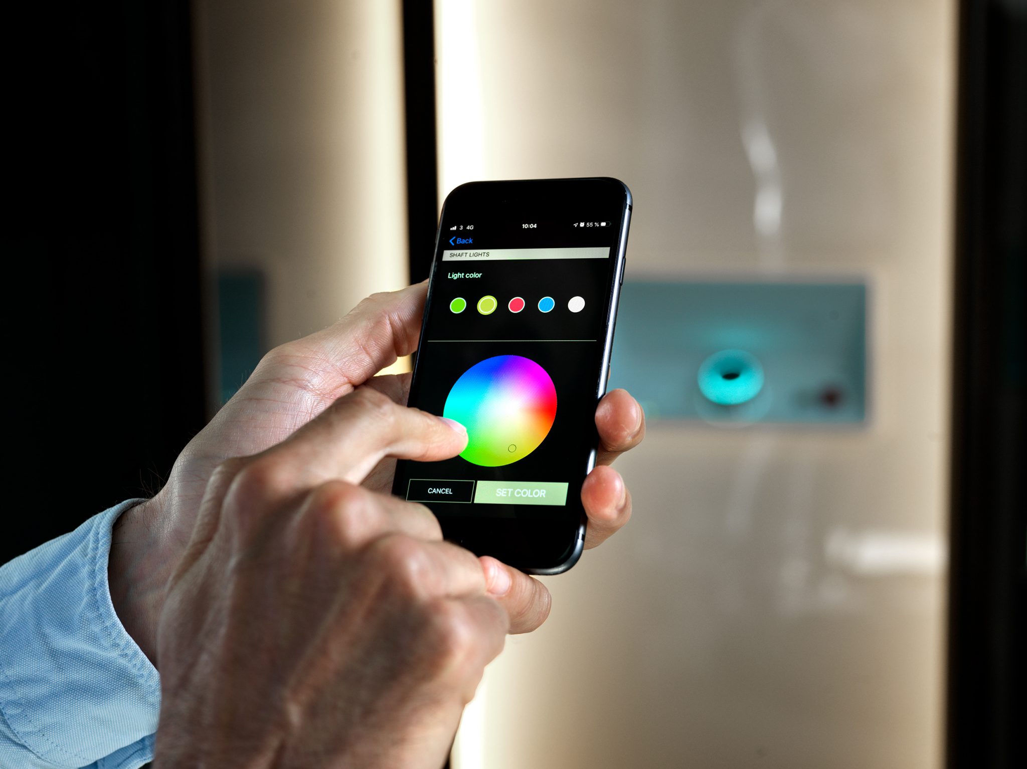 Picture of a hand with a smarthphone controlling the color of the lights inside the home lift Aritco HomeLift