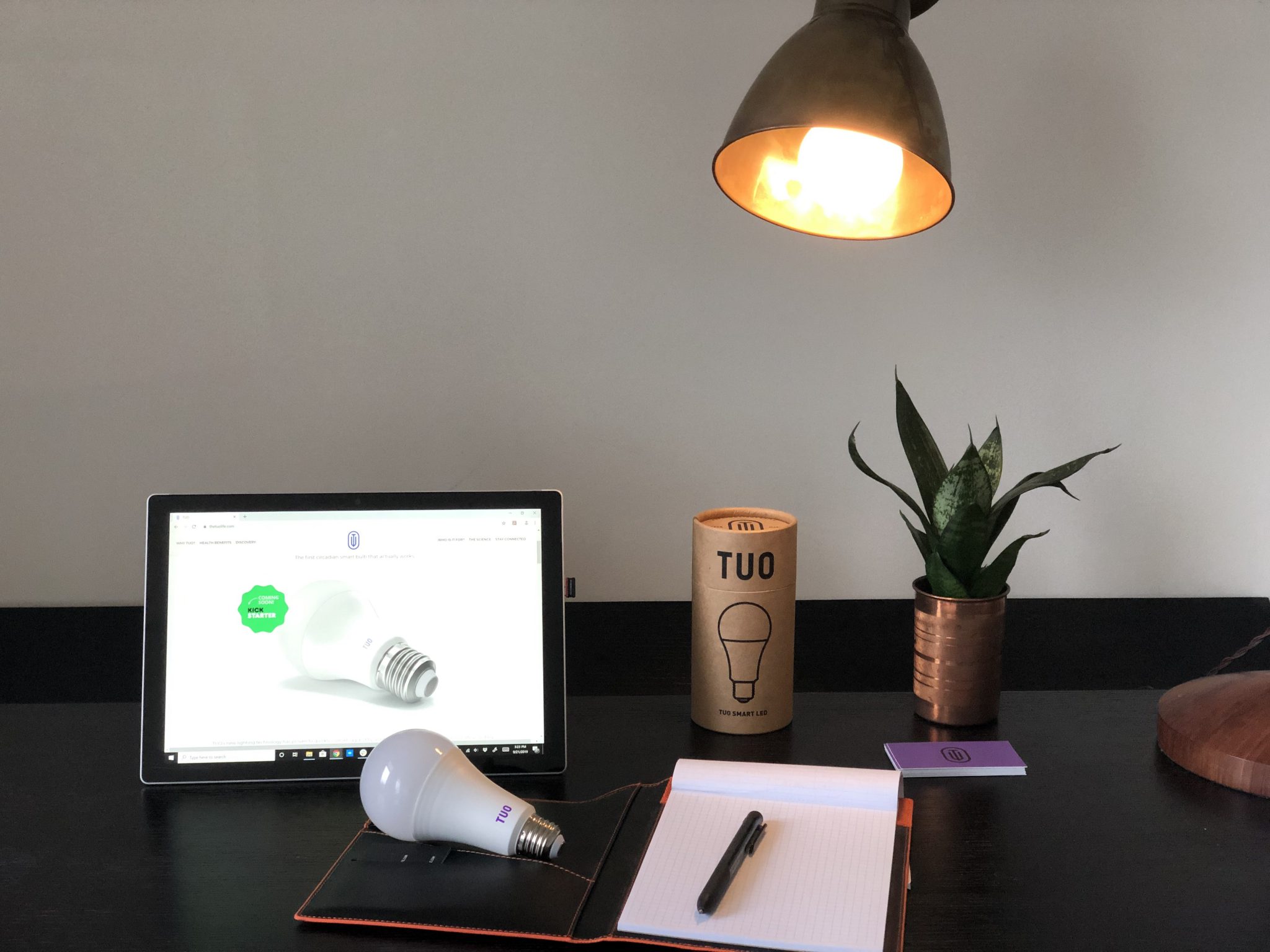 Laptop on a desk with the light of a lamp on it