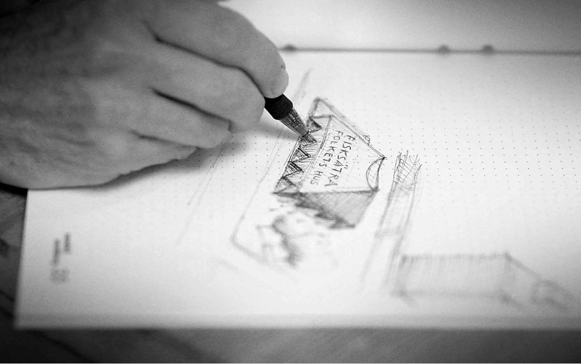 a hand sketching on a piece of paper