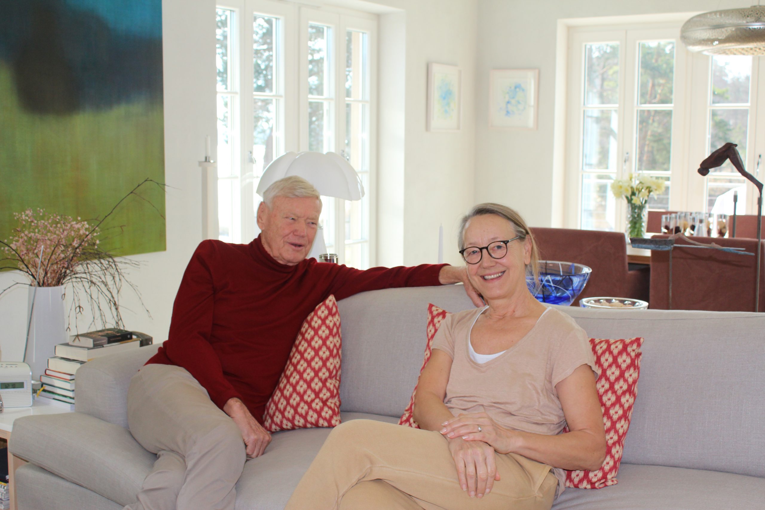 An olderly man and a woman sitting in a sofa in theire 